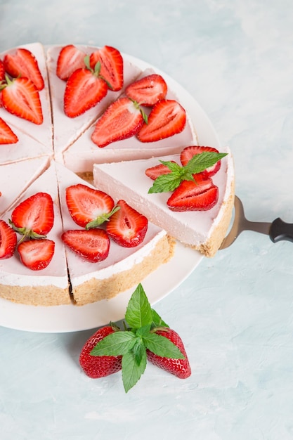 Zoet ontbijt heerlijke cheesecake met verse aardbeien en munt zelfgemaakt recept zonder bakken op een blauwe stenen tafel Kopieer ruimte