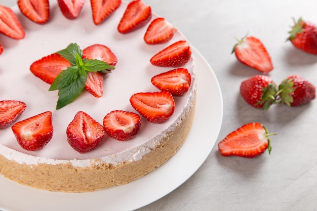 Zoet ontbijt heerlijke cheesecake met verse aardbeien en munt zelfgemaakt recept zonder bakken op een stenen tafel Kopieer ruimte