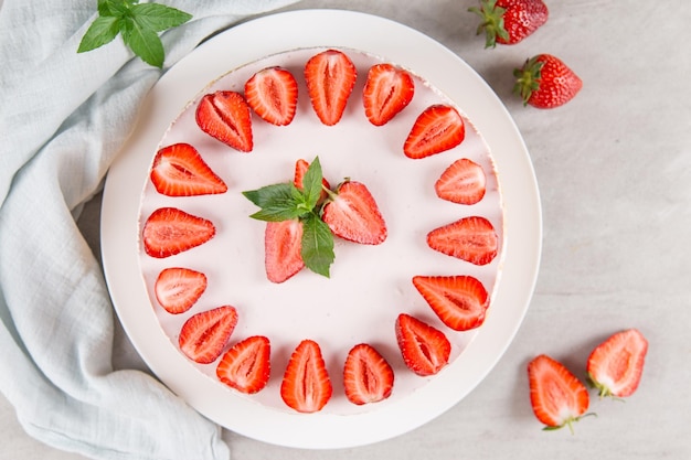 Zoet ontbijt heerlijke cheesecake met verse aardbeien en munt zelfgemaakt recept zonder bakken op een stenen tafel Kopieer ruimte