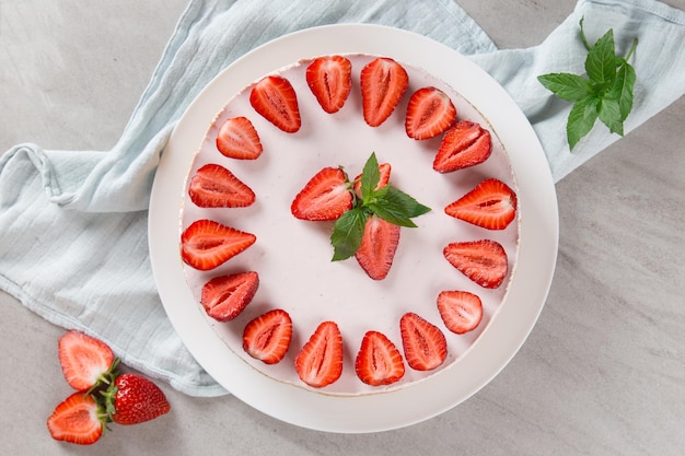 Zoet ontbijt heerlijke cheesecake met verse aardbeien en munt zelfgemaakt recept zonder bakken op een stenen tafel Kopieer ruimte