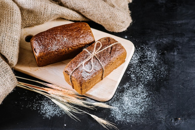 Zoet roggebrood met verschillende ingrediënten op zwarte houten achtergrond