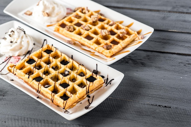 Zoet wafeldessert met chocolade en roomijs op houten achtergrond