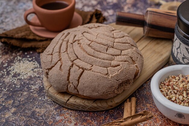 Zoet zelfgemaakt rustiek brood op een tafel, complementeer met een kopje koffie, traditioneel bakkersstuk