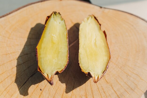 Zoete aardappel in tweeën gesneden op houten bord