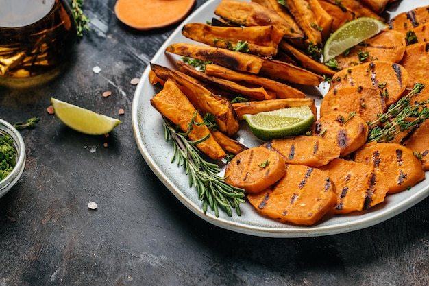 Zoete aardappelfrietjes op plaat op donkere achtergrond. banner, menu, receptplaats voor tekst, bovenaanzicht