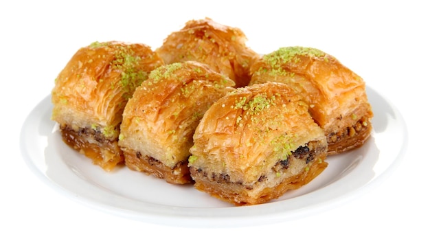 Zoete baklava op plaat die op wit wordt geïsoleerd