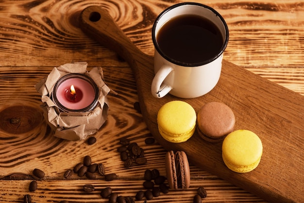 Zoete bitterkoekjes op een houten bord met kopje koffie en een brandende kaars Sfeervolle foto-inhoud voor sociale netwerken