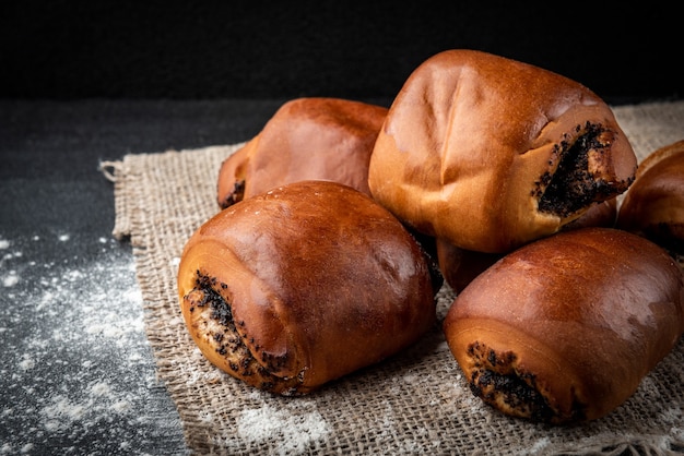 Zoete broodjes met maanzaad op donkere achtergrond.