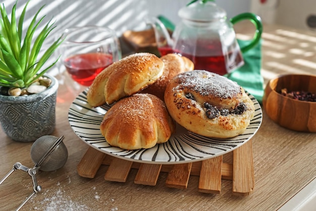 Zoete broodjes op een bord en hibiscusthee op een houten tafel met natuurlijk licht