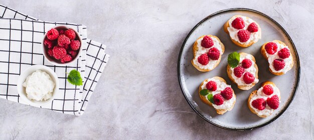 Zoete bruschetta's met kaas en frambozen op een bord