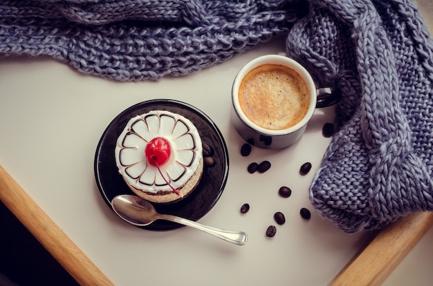 Zoete cake met een kers en een kopje koffie