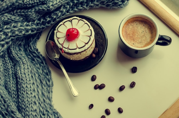 Zoete cake met een kers en een kopje koffie