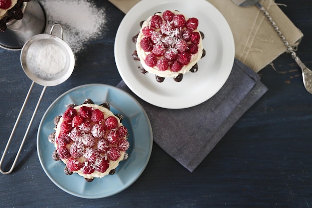 Foto zoete cakes met frambozen op een kleurrijke houten achtergrond