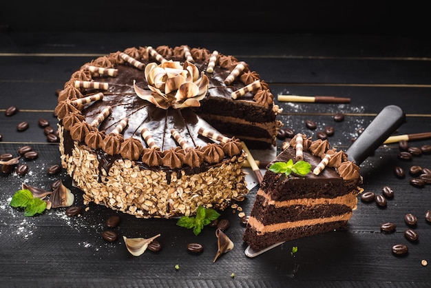 Foto zoete chocoladetaart met lekkere room op de zwarte houten achtergrond