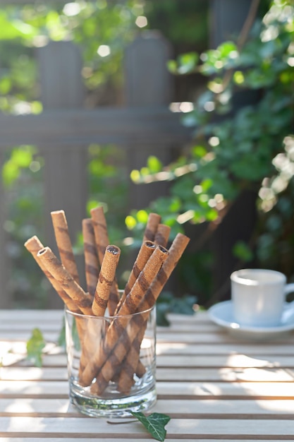 Zoete chocoladetubes met chocoladeroom in een kopje op tafel