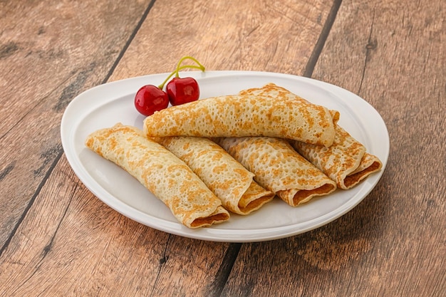 Zoete en smakelijke zelfgemaakte pannenkoek met kersenjam.