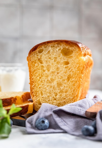 Zoete franse brioche geserveerd met honing en bosbessen voor een gezond ontbijt zelfgebakken brood