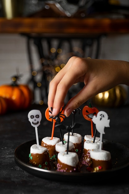 Foto zoete halloween-traktatie met chocolade bedekte marshmallows met suiker en halloween-versieringen op een