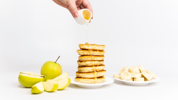 Zoete huisgemaakte pannenkoeken met banaan, appel en honing of ahornsiroop