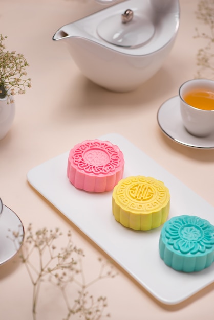 Zoete kleur van sneeuwhuid mooncake. Traditioneel mid-herfstfestivalvoedsel met thee op tafel.