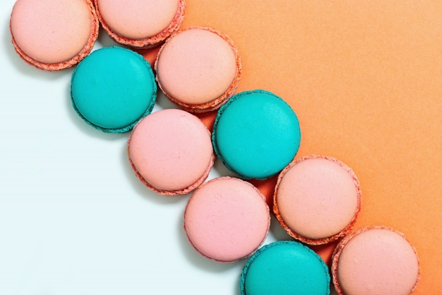 Zoete kleurrijke bitterkoekjes. Rij van munt en roze macarons. Bovenaanzicht. Ruimte kopiëren. Pastelkleuren.