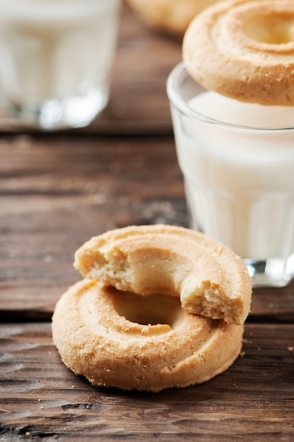 Zoete koekjes en glazen melk op houten tafel