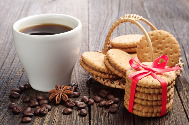 Zoete koekjes gebonden lint en kopje koffie op een houten tafel