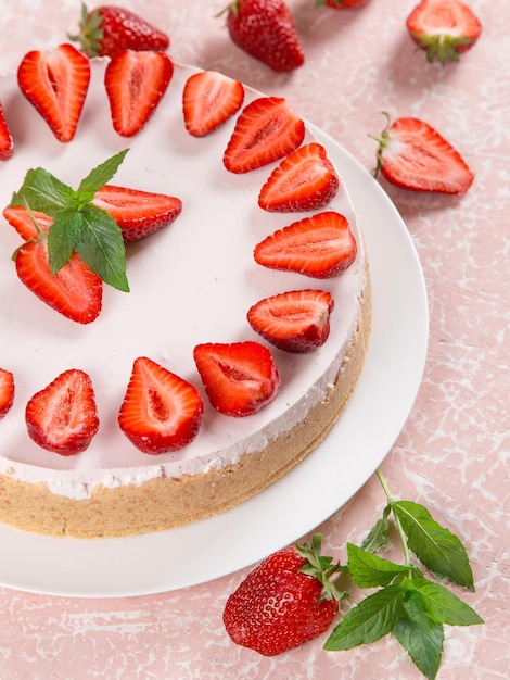Zoete ontbijt heerlijke cheesecake met verse aardbeien en munt zelfgemaakt recept zonder bakken op een roze stenen tafel Kopieer ruimte