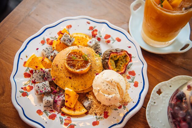 Zoete pannenkoeken met honing en vanille-ijs Fruit met oranje focus op pannenkoek