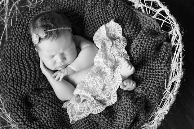 Zoete pasgeboren babymeisje slaapt in de mand Donkerbruine achtergrond