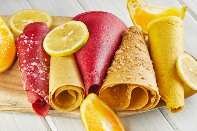 Zoete pastille gemaakt van puur fruit op rolletjes met citrusvruchten. Gezonde snoepjes - lollies, fruit