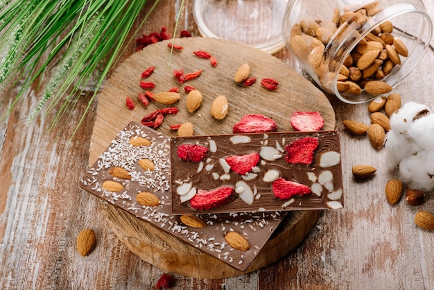 Zoete reep chocolade met fruit en noten op de houten achtergrond