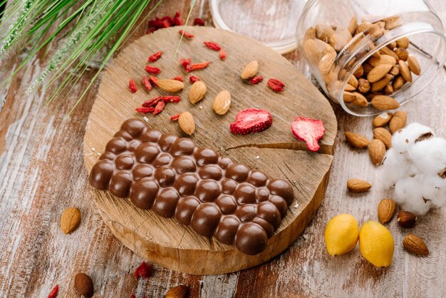 Zoete reep chocolade met fruit en noten op de houten achtergrond