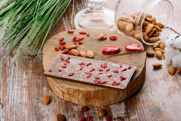 Zoete reep chocolade met fruit en noten op de houten achtergrond