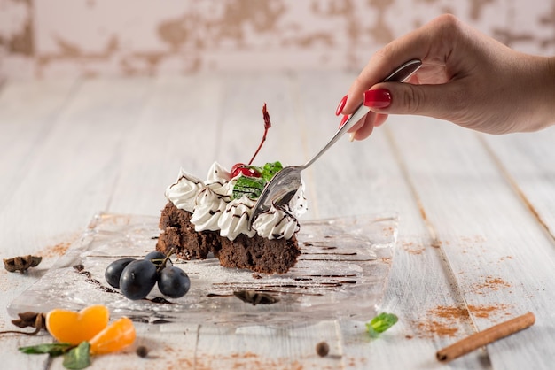 Zoete romige cake met vruchten op de witte houten achtergrond