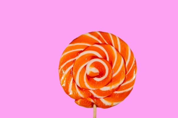 Zoete sinaasappel lolly op roze achtergrond