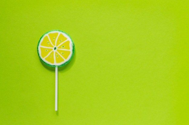 Zoete smakelijke lolly in de vorm van limoenplak. Minimale plat lag met kopie ruimte