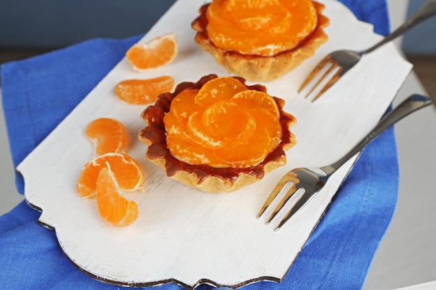 Zoete taarten met mandarijnen op tafel close-up
