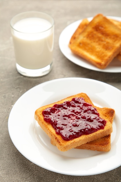 Zoete toast met jam en fruit met melk voor het ontbijt, verticaal. Bovenaanzicht