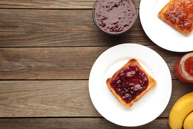 Zoete toast met jam en fruit voor het ontbijt op grijze tafel, horizontaal