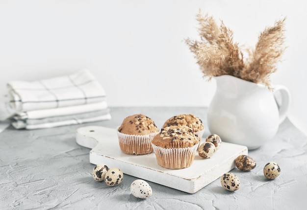 Zoete zelfgemaakte cupcake en kwarteleitjes van Pasen. Wenskaart. Feestelijk eten. Tafel met lekkernijen. Zelfgemaakte taarten en desserts.