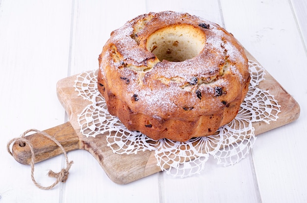 Zoete zelfgemaakte muffin met rozijnen op houten plank.