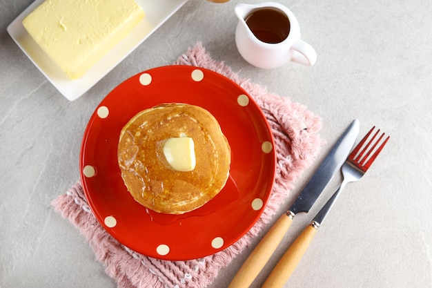 Zoete zelfgemaakte stapel pannenkoeken met boter en honingsiroop als ontbijt