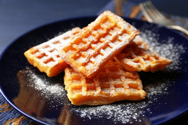 Zoete zelfgemaakte wafels op plaat op donkere houten achtergrond