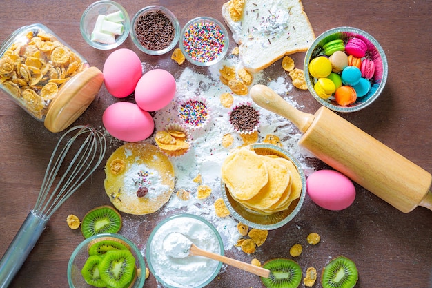 Foto zoetwaren en taartbenodigdhedenkommen met ingrediënten die nodig zijn voor het bakken van kleurrijke cupcakes