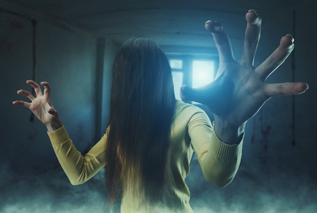 Фото Девушка-зомби с длинными волосами на лице в заброшенном здании