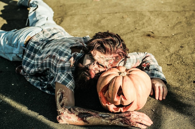 Zombie man lies on pumkin