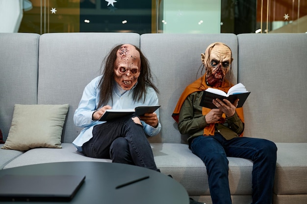 Zombiemedewerkers lezen zittend op de bank