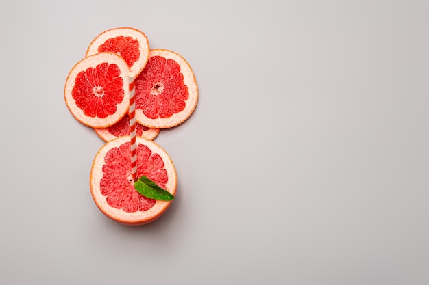 Zomer achtergrond concept: gesneden grapefruit, munt op grijze achtergrond