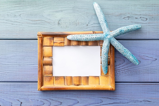 Zomer achtergrond fotolijst, zeester op een blauwe houten achtergrond